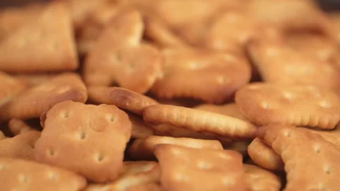 Many of small cracker cookies of different shapes are rotating, close up. Video stock 241014609