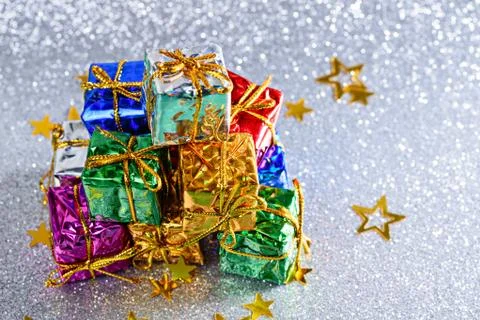 Many small gift boxes on silver shiny background with stars Stock Photos