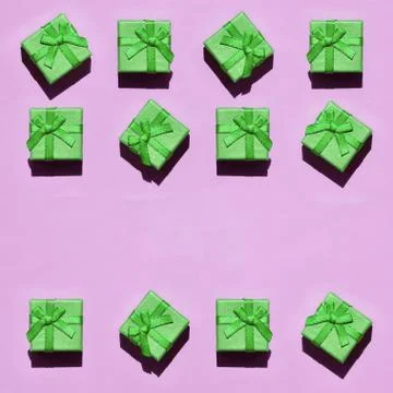 Many small green gift boxes on texture background of fashion trendy pastel pi Stock Photos