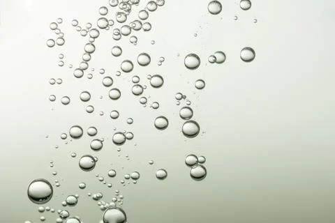 Many small light fizz bubbles flows over a blurred background Stock Photos