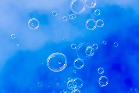 Many small soap bubbles rising against blue sky background Foto stock