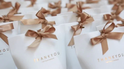 Many small white paper gift boxes with ribbon bows on the table. Stock-Footage 109435628