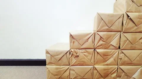 Many stack of brown package boxes on white wall background with copy space. Stock Photos