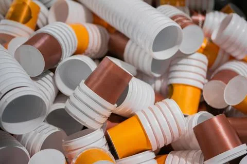 Many stacks of empty orange and brown plastic cups at warehouse - close up Stockfoto's