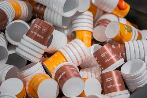 Many stacks of empty orange and brown plastic cups at warehouse - close up Stockfoto's