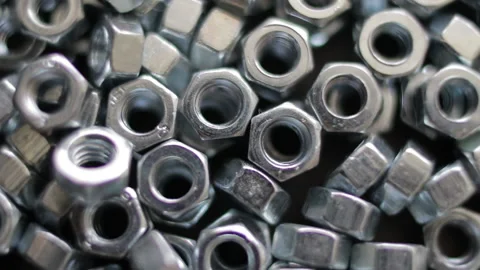 Many stainless hex nuts rotating close-up. Metal industry concept. Stock Footage 229957039