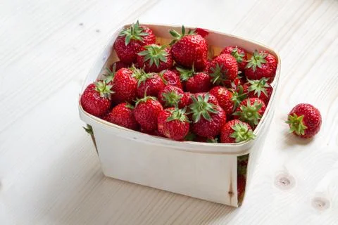 Many strawberries in a wooden basket Stock Photos