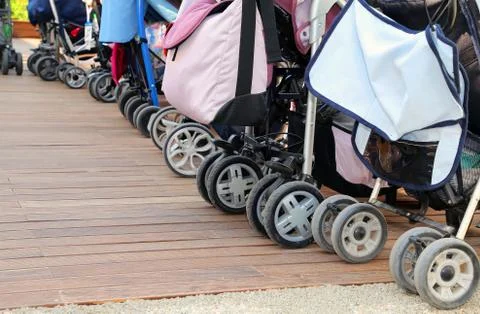 Many strollers for toddlers parked on the parquet floor of wood Stock-Fotos