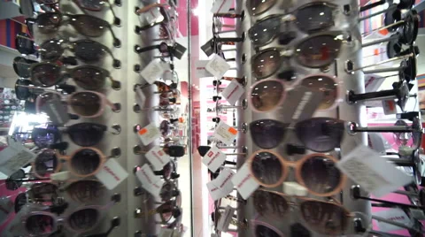 Many sunglasses on white wall background. Showcase with glasses. Stock Footage 61234774
