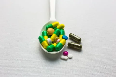 Many tablets and capsules pills on a spoon Stock Photos