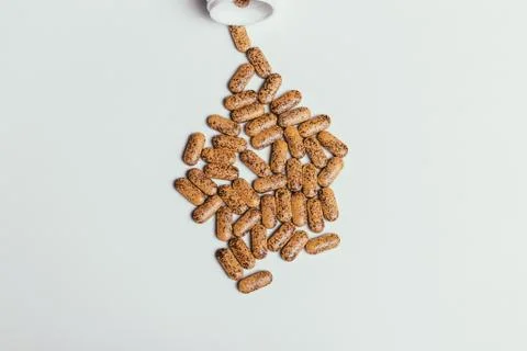 Many tablets and upside down bottle on a white table top view Stock Photos