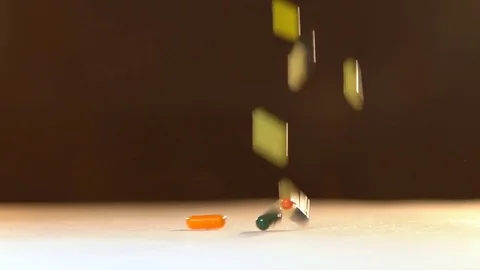 Many tablets fall to the table. A rain of pills slow motion. Stock Footage 73034654