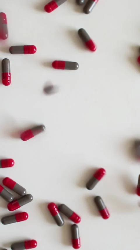 Many tablets fall to the table. A rain of pills. Vertical video. Stock Footage 270068074