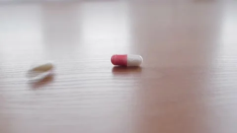 Many tablets fall to the table. Throwing many pills. Stock Footage 130880807