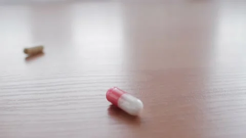 Many tablets fall to the table. Throwing many pills. Stock Footage 130881457