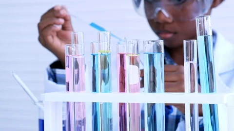 Many test tubes and blur background with African boy doing scientist experiment. Stock Footage 119909704