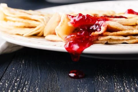 Many thin pancakes with jam on the table Stock Photos
