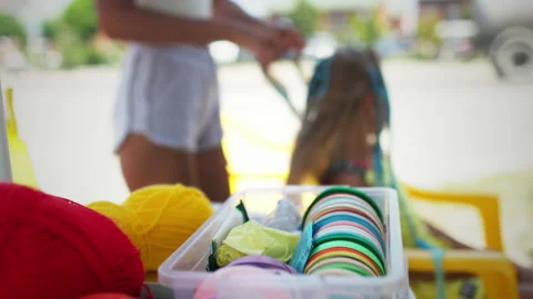 Many threads and ribbons lie on the table against the background of a girl whose Vidéo 172336254