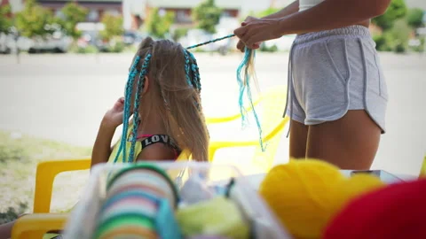 Many threads and ribbons lie on the table against the background of a girl whose Vidéo 178604786