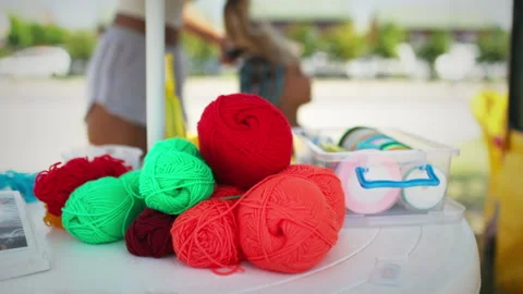 Many threads and ribbons lie on the table against the background of a girl whose Vidéo 201247948