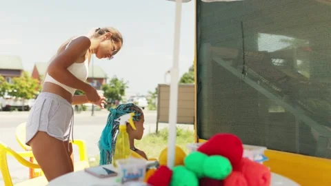 Many threads and ribbons lie on the table against the background of a girl whose Stock Footage 348024463