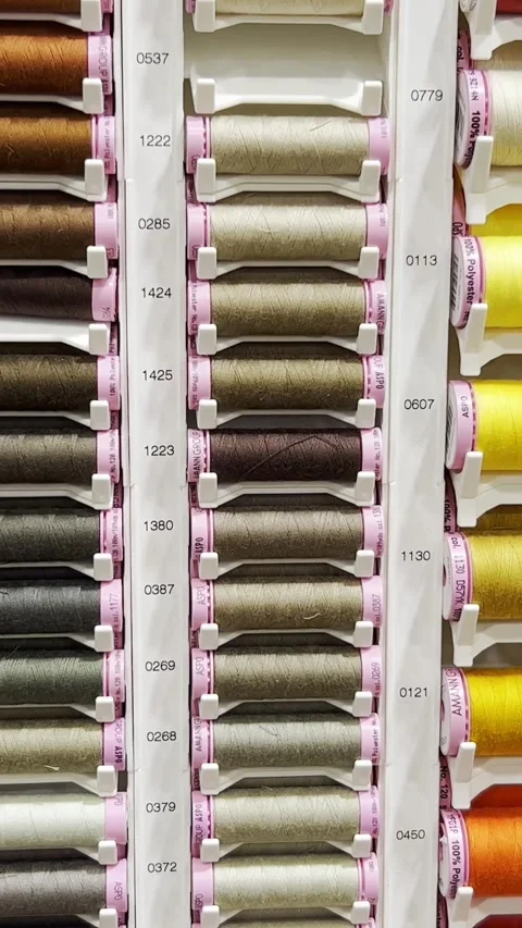 Many threads of different colors placed on racks in the workshop of a clothing Video stock 250386123