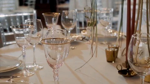 Many transparent glasses stand on a table with a white tablecloth Stock Footage 119781519