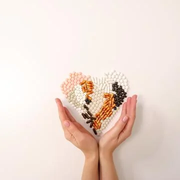 Many types of pills on a light background are folded in the form of a heart Stock Photos