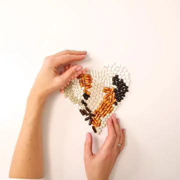 Many types of pills on a light background are folded in the form of a heart Stock Photos