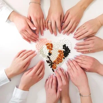 Many types of pills on a light background are folded in the form of a heart Stock Photos