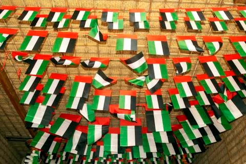 Many UAE flags and decorations on old Dubai city background. National Day Stock Photos
