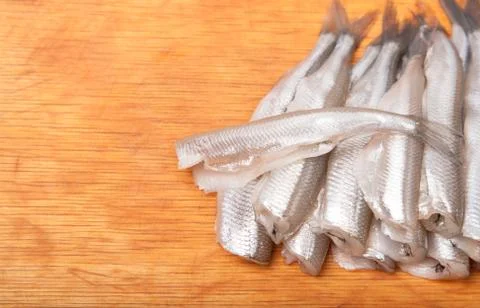 Many uncooked trunk small fish on wood Foto stock
