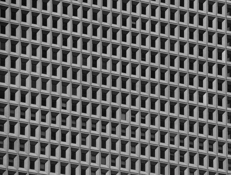 Many uniformly square windows of a modern reinforced concrete building Foto stock