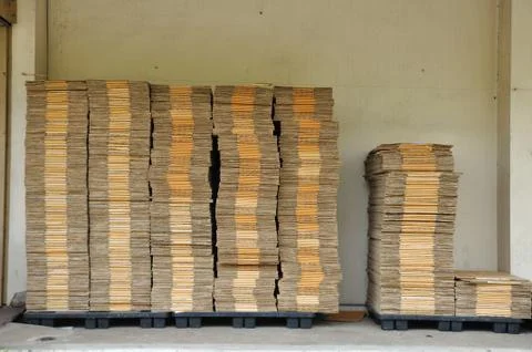 Many unpack paper box stacking on black pallet in front of warehouse. Stock Photos