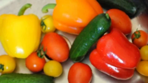 Many vegetables of various kinds lick in the sink and are ready for washing. Red Stock Footage