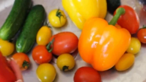 Many vegetables of various kinds lick in the sink and are ready for washing. Red Stock Footage 77602349