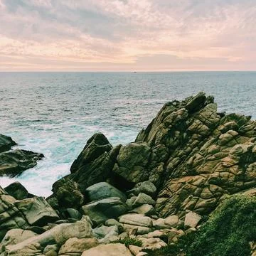 Many very small waves that are going to crash against the rocks Stock Photos