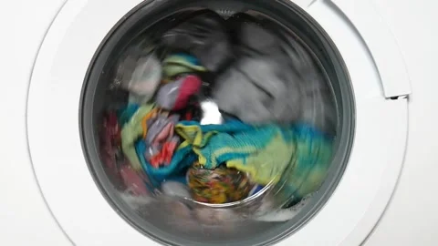 Many washable clothes in the drum of a home washing machine Stock Footage 276710287