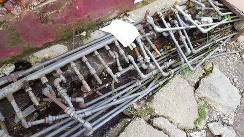 Many water pipes lead to different places, plumbing intersection, leak, India Stock Footage 70736419