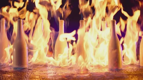 Many white bottles burning on fire in slow motion Stock Footage 153384482