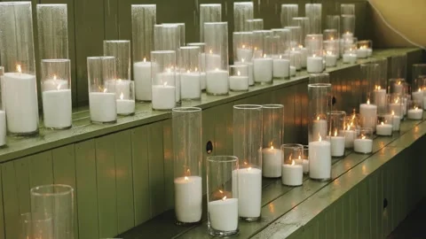 Many white candles with raindrops falling on them while burning, rain at a Stock Footage 318064737