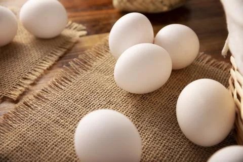 Many white chicken eggs on rustic wooden table. Very popular nutritious and e Stock Photos
