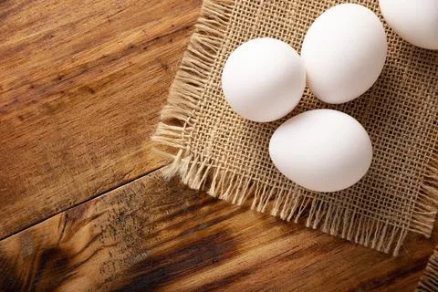 Many white chicken eggs on rustic wooden table. Very popular nutritious and e Stock Photos