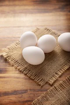 Many white chicken eggs on rustic wooden table. Very popular nutritious and e Stock Photos