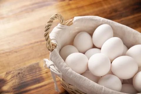 Many white chicken eggs on rustic wooden table. Very popular nutritious and e Stock Photos