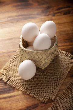 Many white chicken eggs on rustic wooden table. Very popular nutritious and e Stock Photos