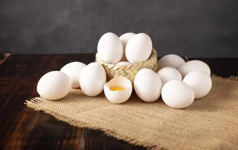 Many white chicken eggs on rustic wooden table. Very popular nutritious and e Stock Photos