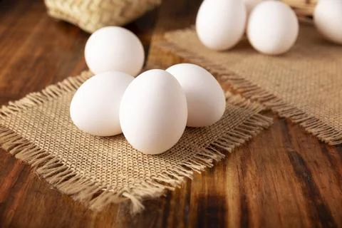 Many white chicken eggs on rustic wooden table. Very popular nutritious and e Stock Photos