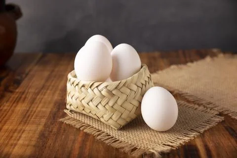 Many white chicken eggs on rustic wooden table. Very popular nutritious and e Stock Photos