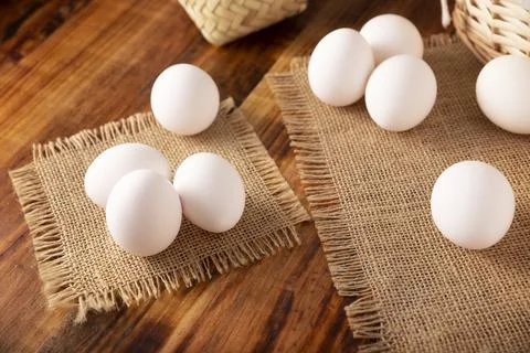 Many white chicken eggs on rustic wooden table. Very popular nutritious and e Stock Photos